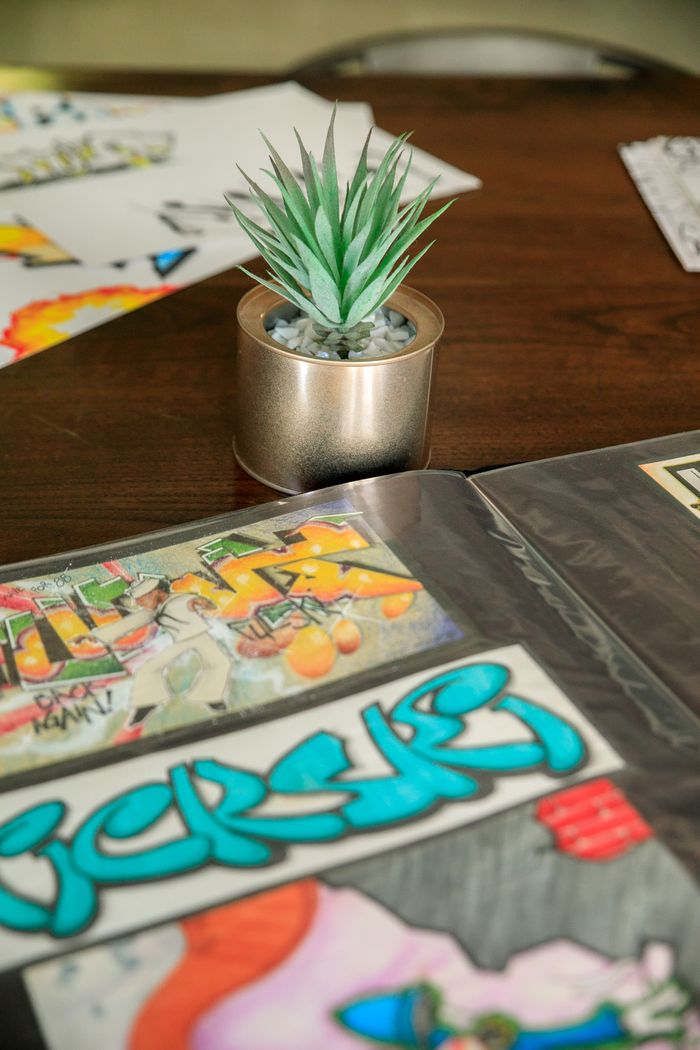 Art portfolio with potted plant on wooden table, showcasing creativity